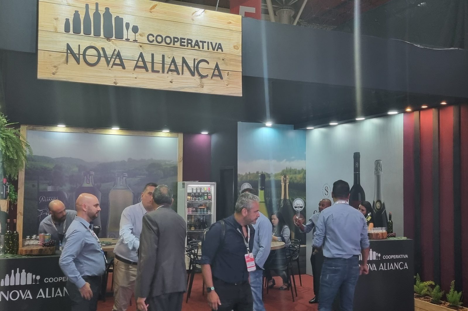 Stand em pavilhão com área de mesas e painel gráfico